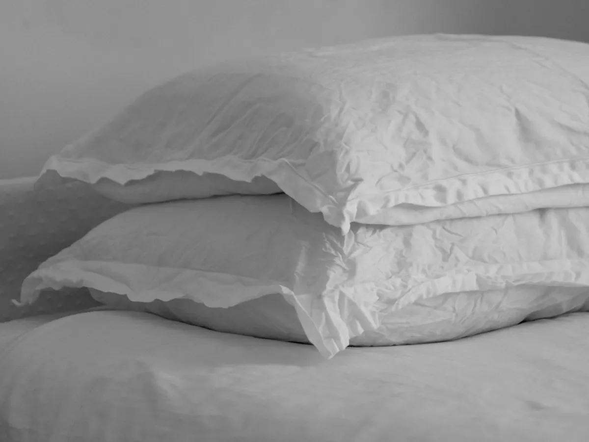 Two white pillows stacked on a neatly made bed