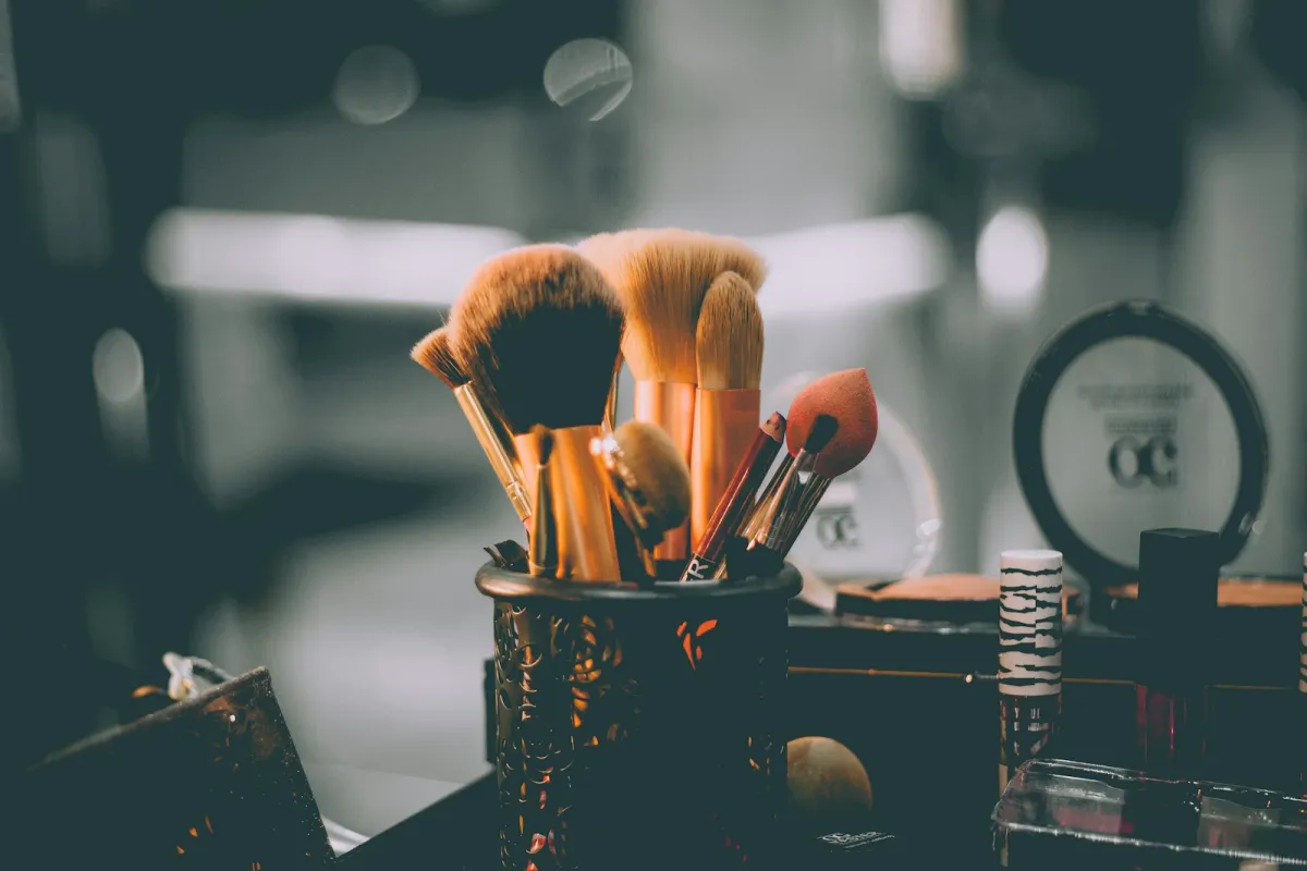 Make-up brushes in a black holder on a dressing table