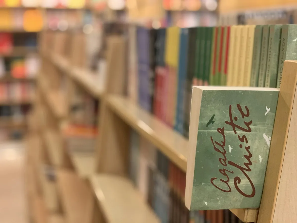 Rows of paperbacks on a bookshop shelf, with the rest of the shop softly out of focus Rows of paperbacks on a bookshop shelf, with the rest of the shop softly out of focus