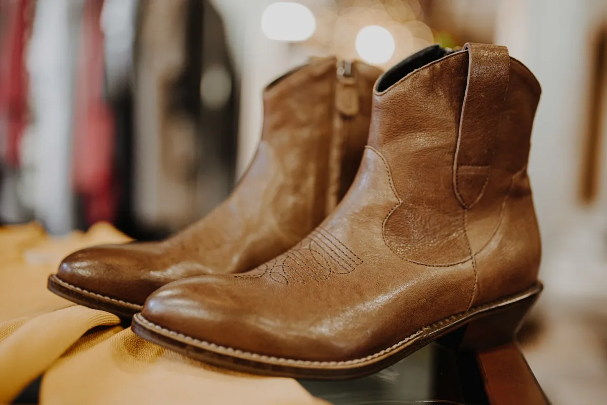 A pair of brown leather ankle boots on a shop display A pair of brown leather ankle boots on a shop display