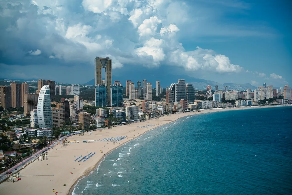 Benidorm's high-rise skyline above a long sandy beach and blue sea