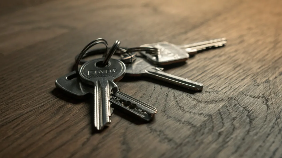 Bunch of house keys on a dark wooden table Bunch of house keys on a dark wooden table
