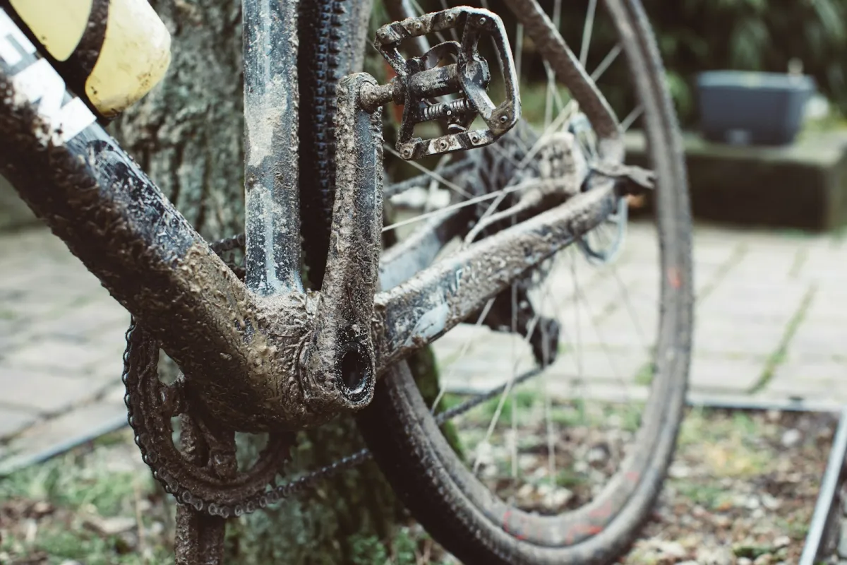 Close-up of a mud-covered bike frame, chainring and pedal Close-up of a mud-covered bike frame, chainring and pedal