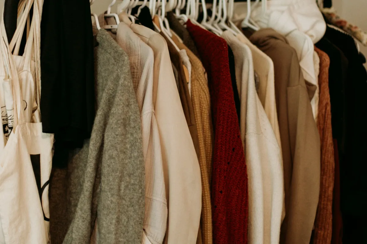 Knitwear and coats in autumn colours hanging on a clothes rail