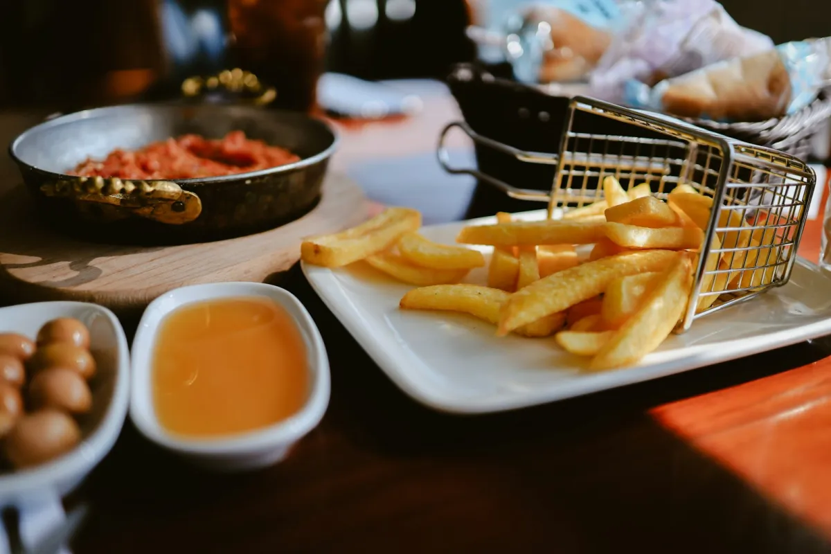 Chips tipped from a wire basket onto a white plate