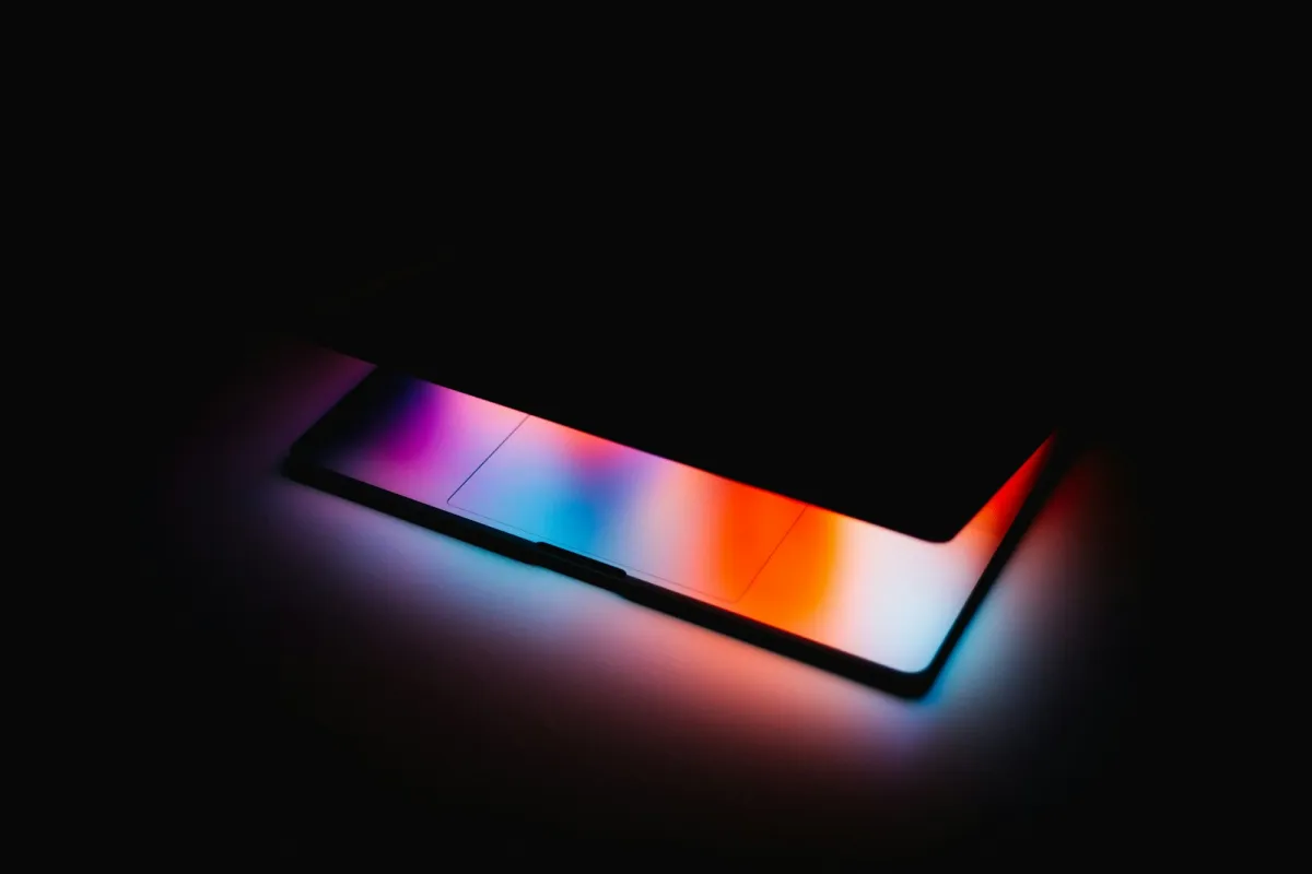 A device glowing with orange, blue and purple light in a dark room