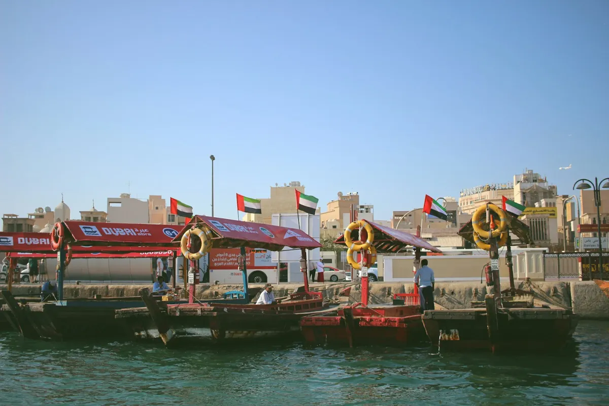 Traditional abra water taxis moored on Dubai Creek under a clear blue sky
