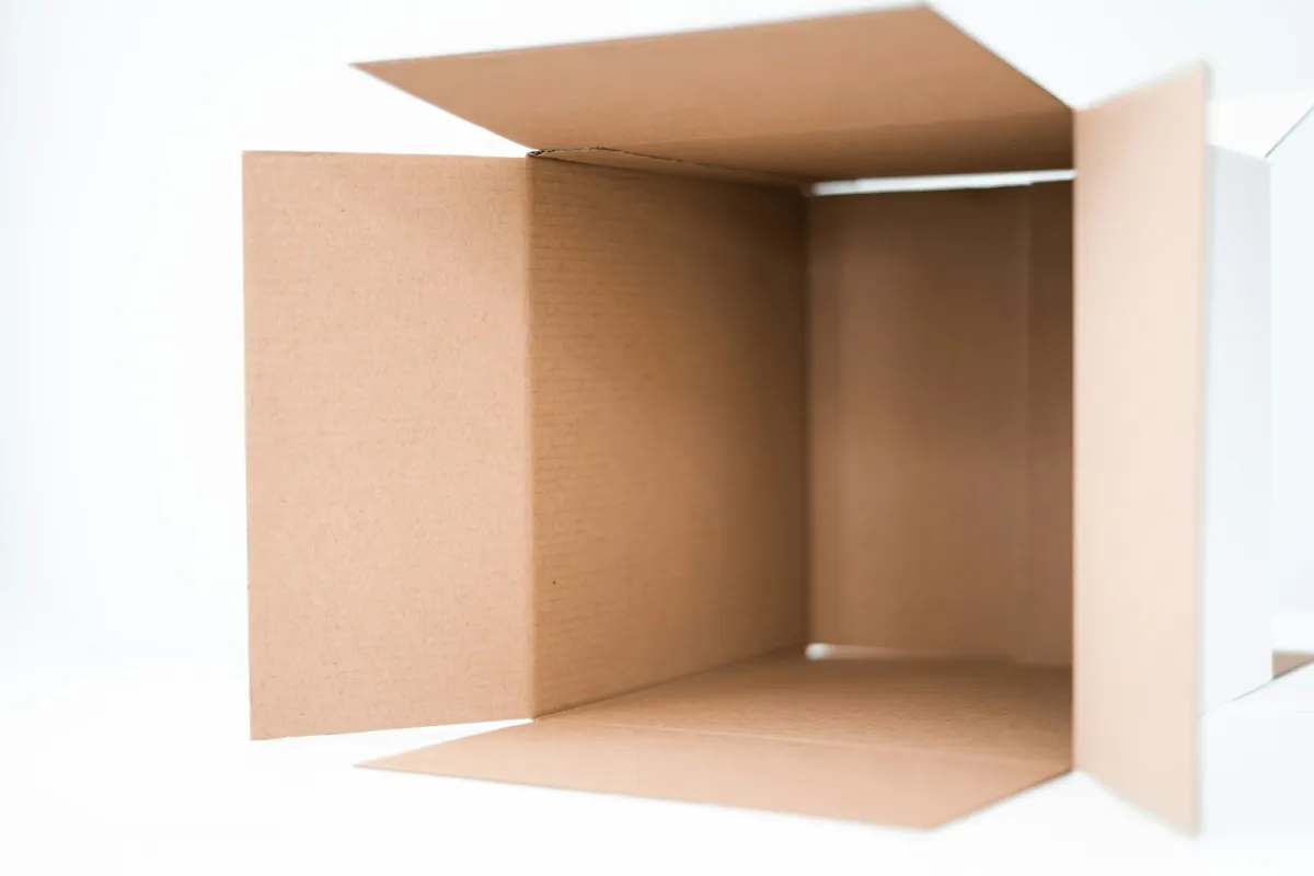 An empty, open brown cardboard box against a white background An empty, open brown cardboard box against a white background