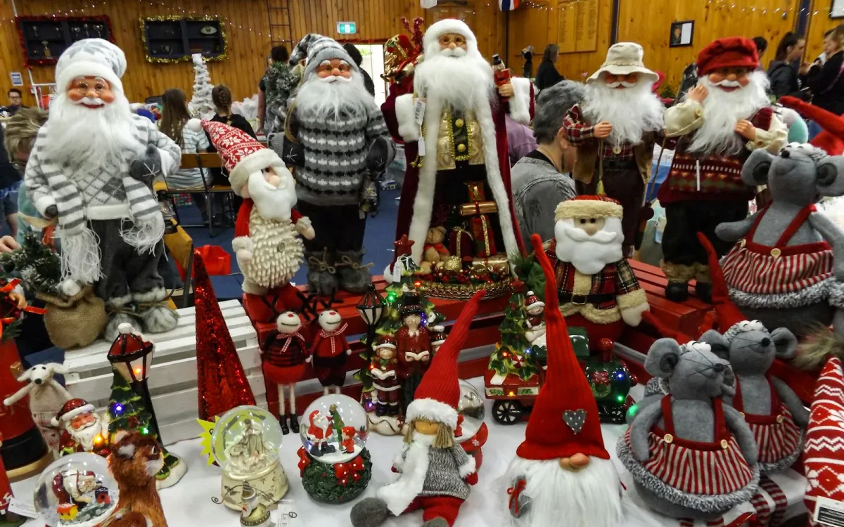 A table crowded with Santa figures, gnomes, snow globes and other Christmas decorations A table crowded with Santa figures, gnomes, snow globes and other Christmas decorations