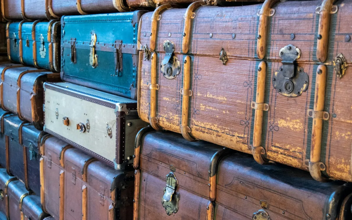 Stacks of old leather and canvas travel trunks with brass clasps Stacks of old leather and canvas travel trunks with brass clasps