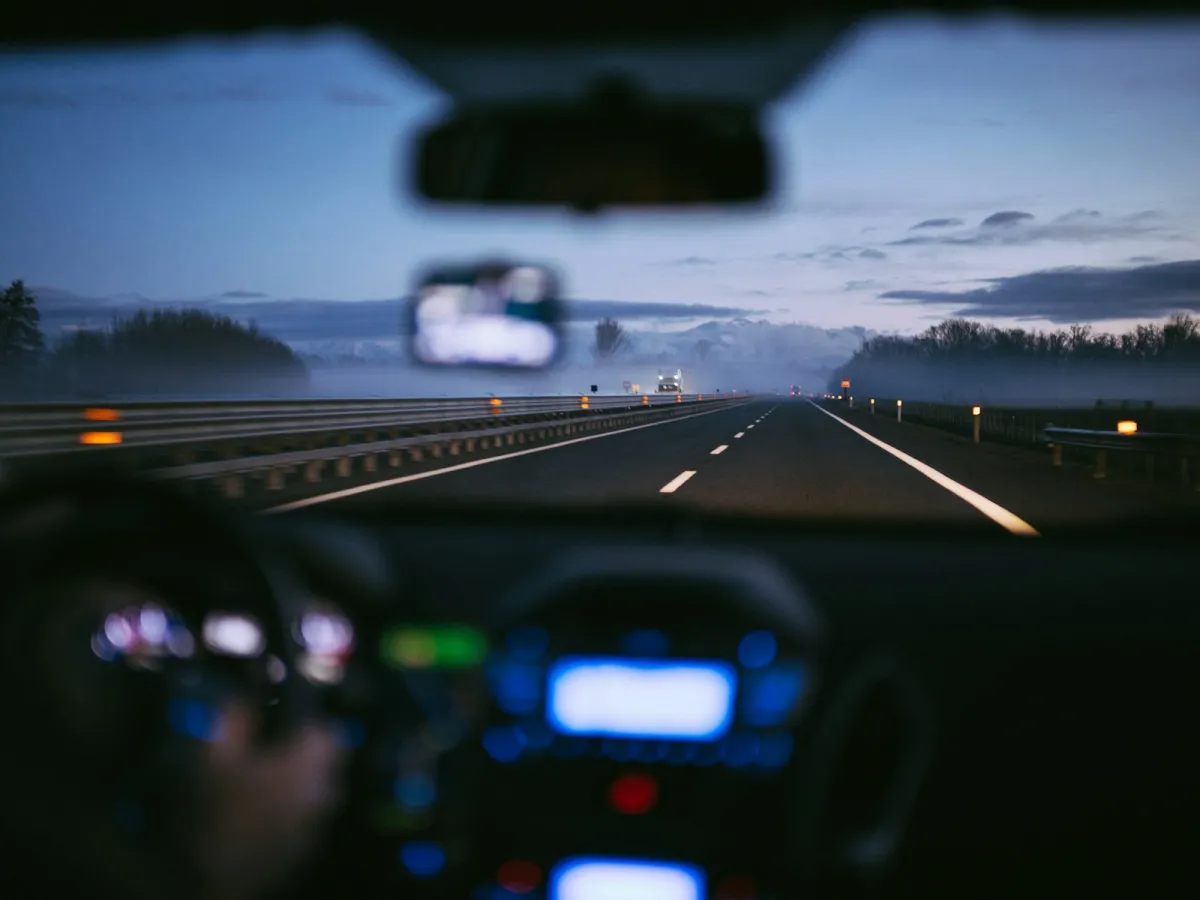 View through a car windscreen of a misty motorway at dusk