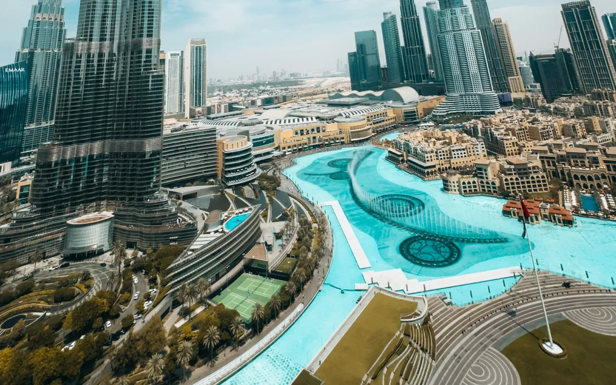 The Burj Khalifa and Downtown Dubai skyscrapers rising above the turquoise Dubai Fountain lake