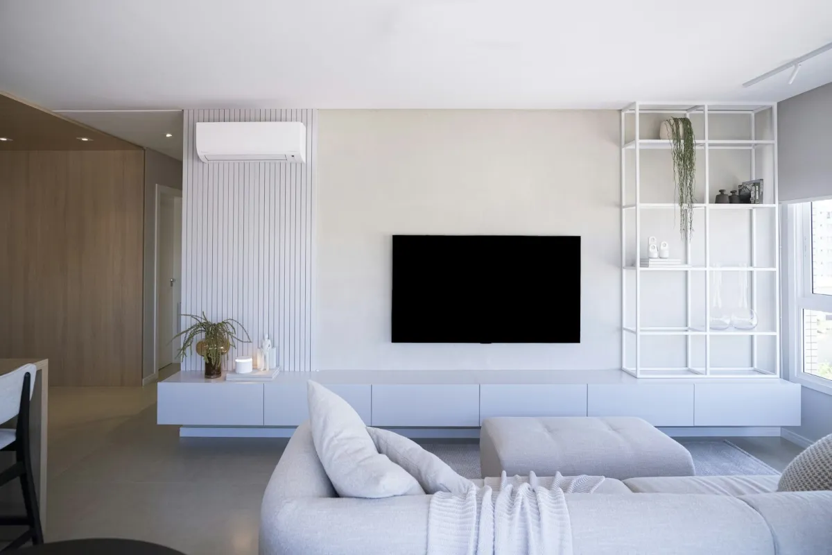 Bright modern living room with a wall-mounted TV and light grey sofa Bright modern living room with a wall-mounted TV and light grey sofa