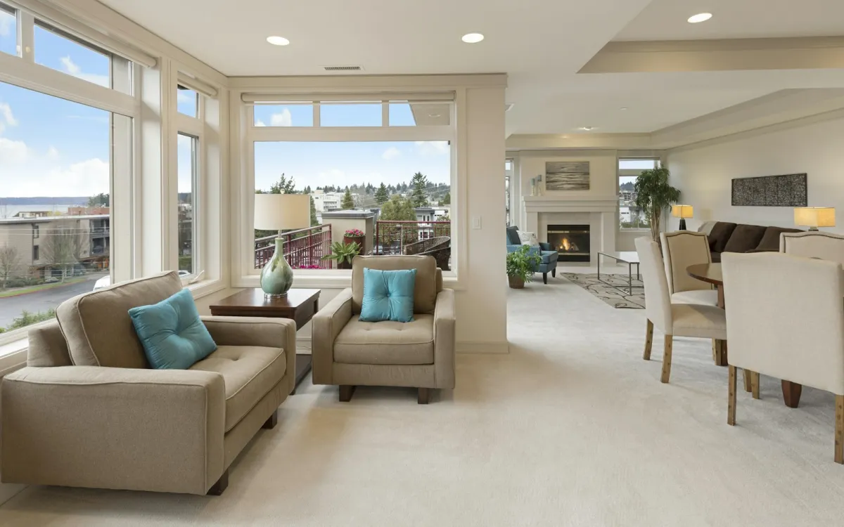 Bright carpeted living room with armchairs by the windows Bright carpeted living room with armchairs by the windows