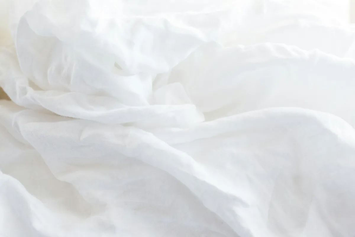 Close-up of soft, crumpled white bed sheets
