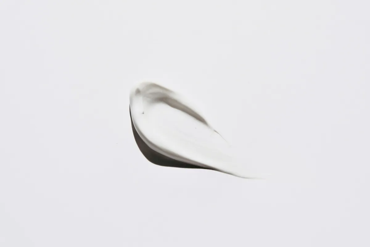 A smear of white cosmetic cream on a plain white background