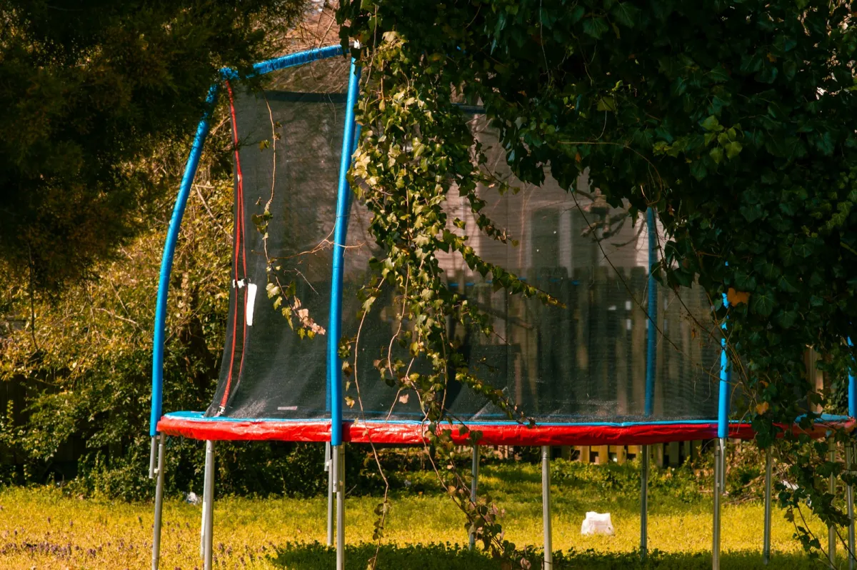 Garden trampoline with a red and blue safety net Garden trampoline with a red and blue safety net