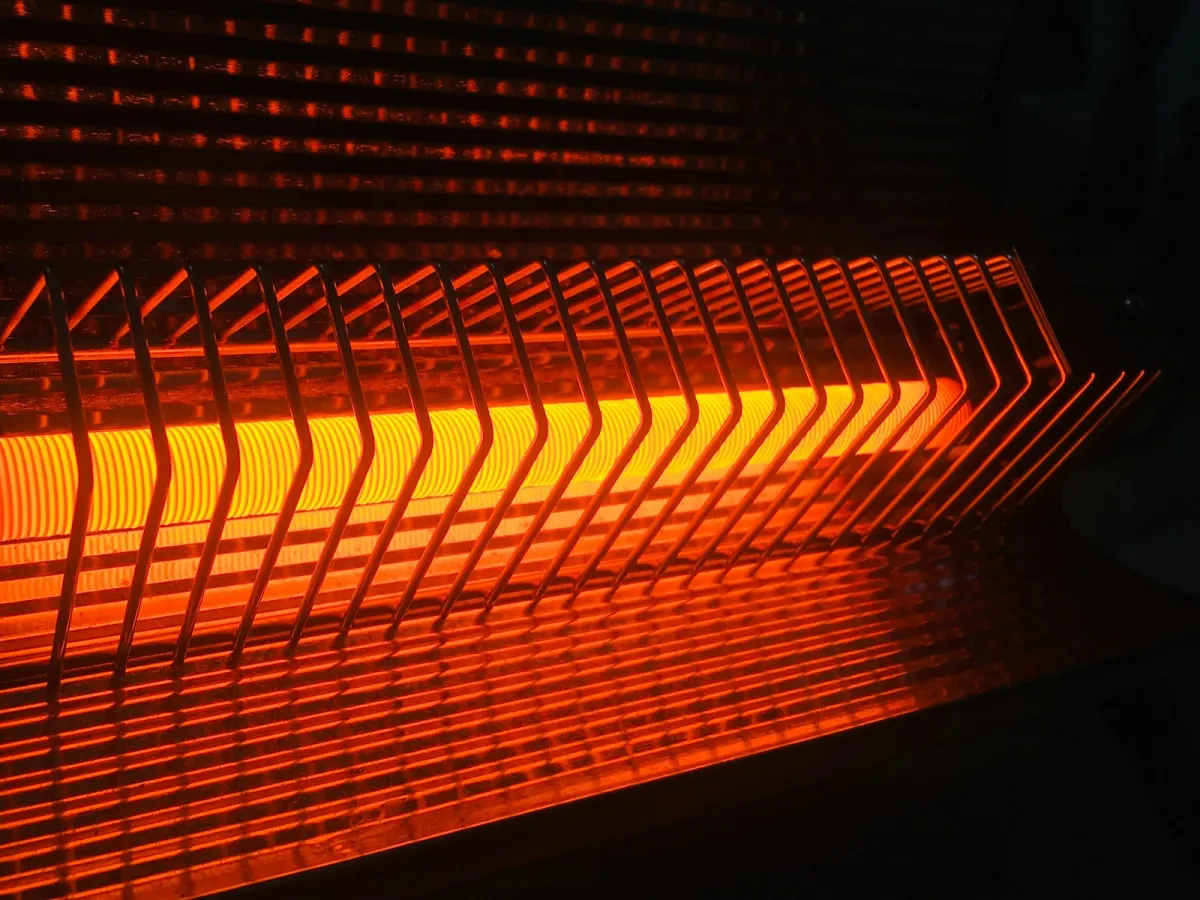 Close-up of a glowing electric heater element behind a wire guard Close-up of a glowing electric heater element behind a wire guard