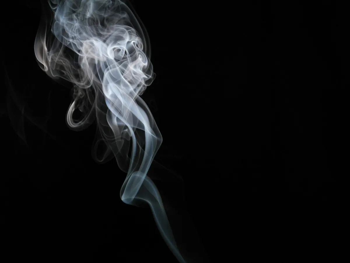 A single plume of white vapour rising against a black background A single plume of white vapour rising against a black background