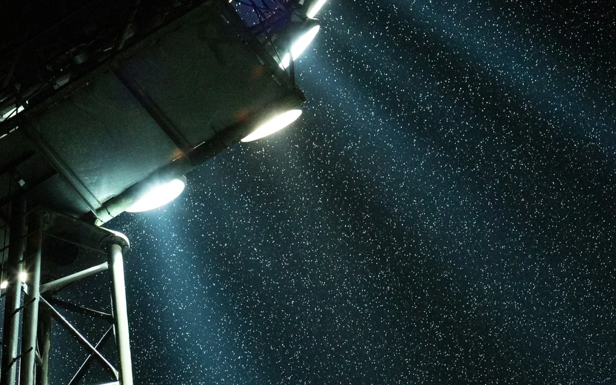 Stadium floodlights shining through falling snow at night Stadium floodlights shining through falling snow at night