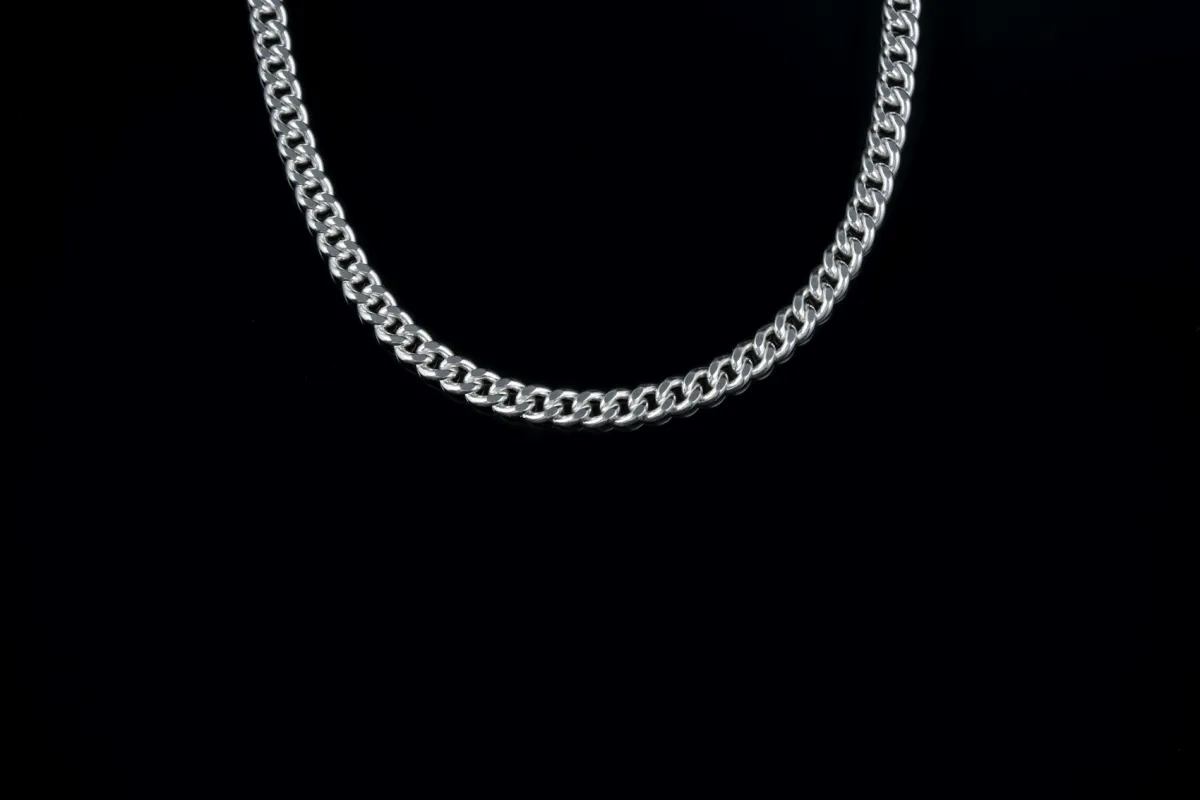 A silver curb chain on a black background