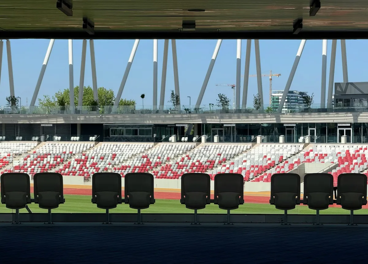 Empty stadium seats and stands under a bright blue sky