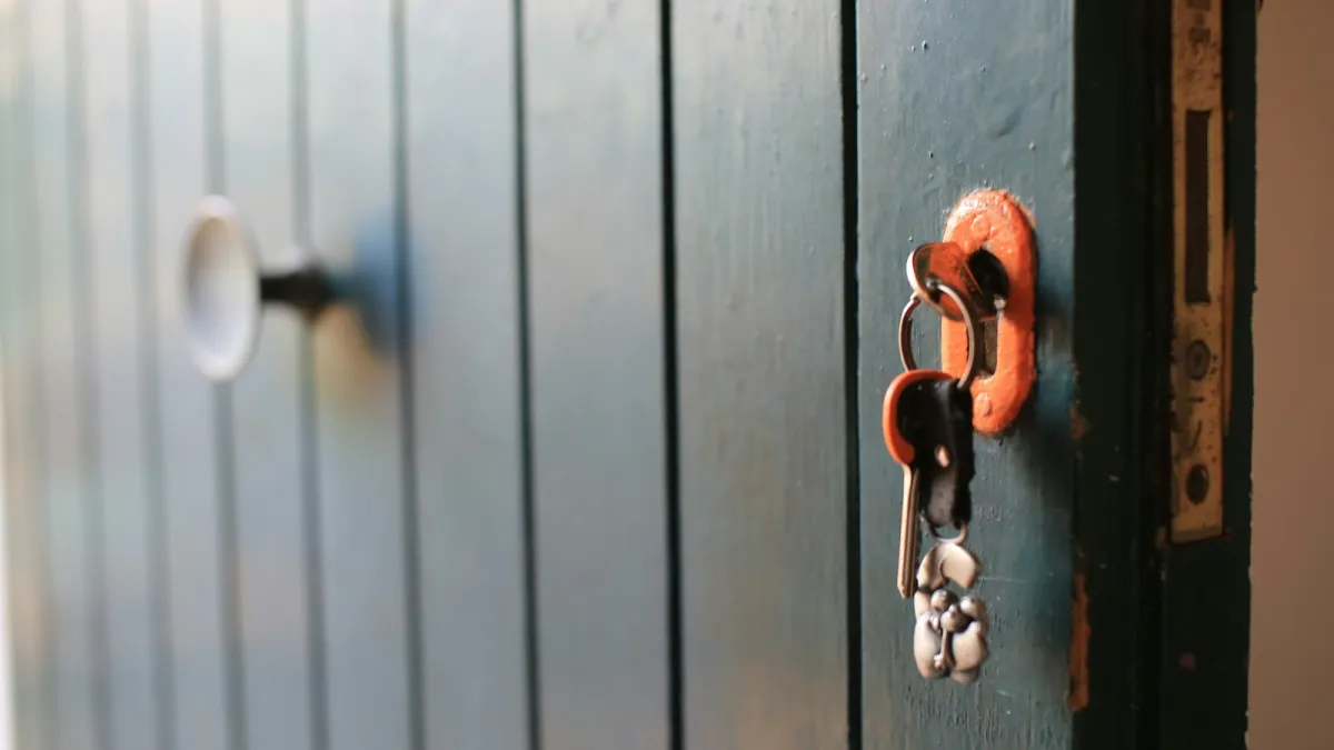 A bunch of keys hanging from the lock of a painted wooden door