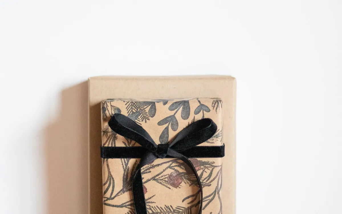 Two presents wrapped in brown patterned paper and tied with a black velvet bow