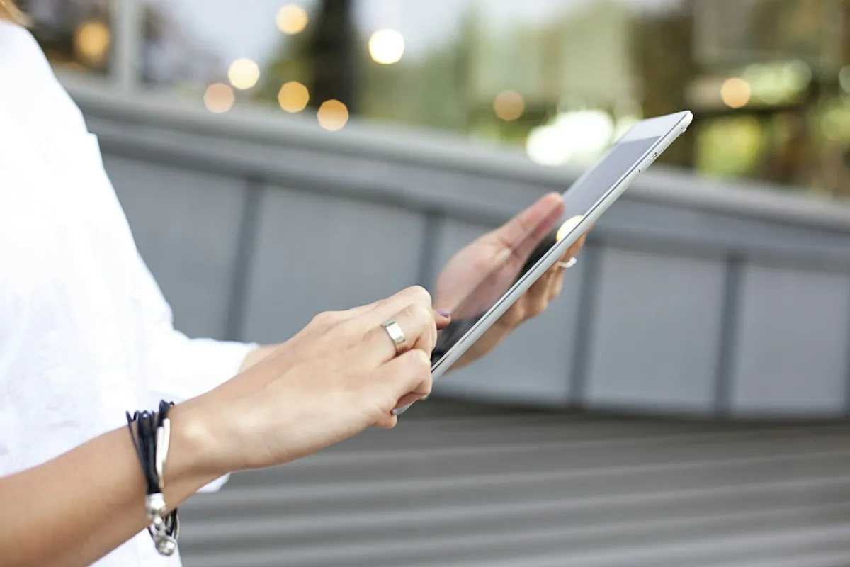 Hands holding a tablet outdoors Hands holding a tablet outdoors