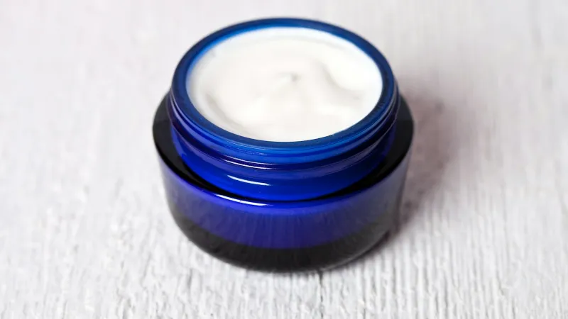 5Kind: hemp, arnica and magnesium creams from Somerset Open blue glass jar of white cream on a pale wooden surface