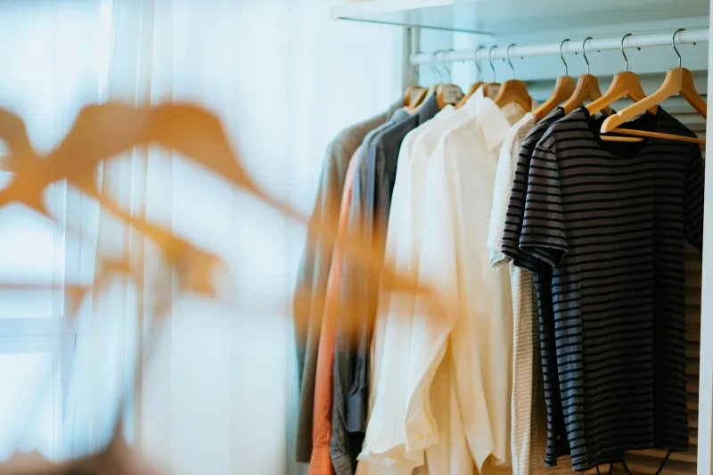 Shirts and a striped T-shirt hanging on a clothes rail