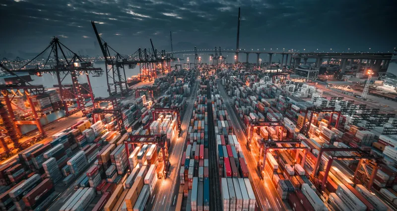Alibaba.com: wholesale sourcing for small businesses and makers A busy container port at dusk, with rows of stacked shipping containers and cranes
