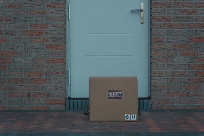 Cardboard parcel left on a doorstep outside a front door