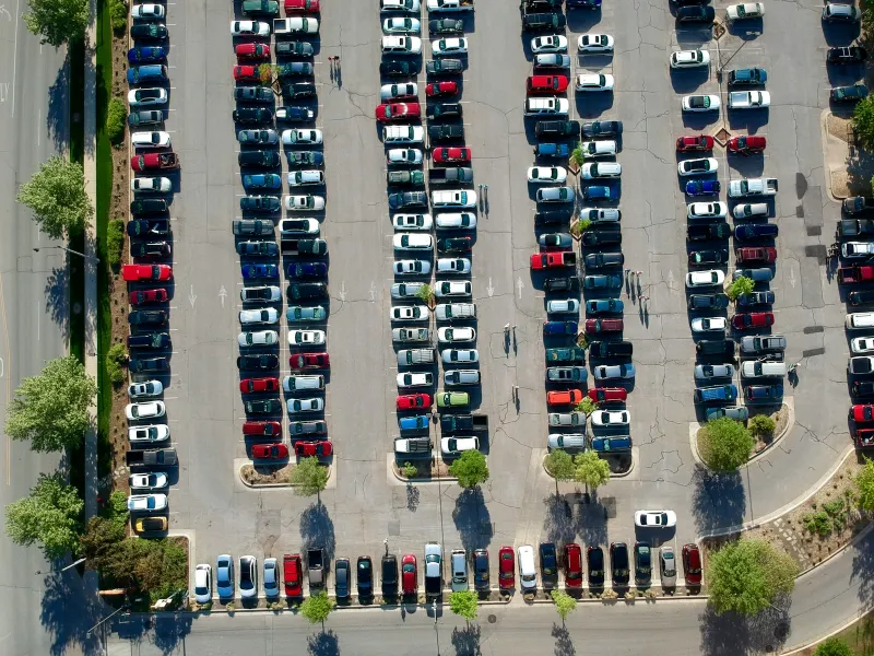 Aerial view of rows of cars in a large open-air car park
