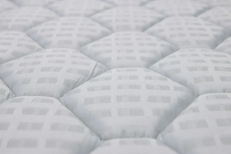 Close-up of a white quilted mattress surface