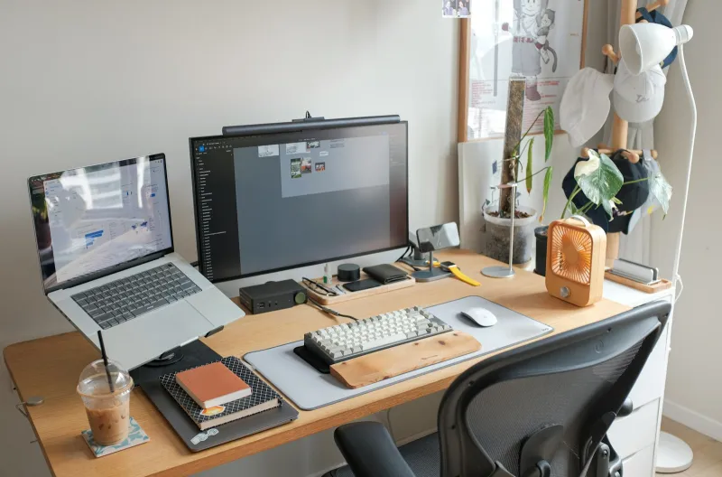 Home office desk with a laptop, monitor and keyboard