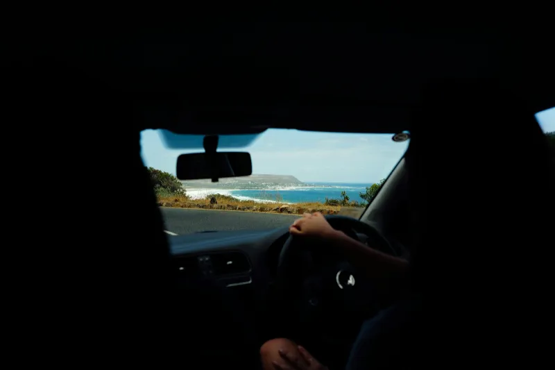 View from a car driving along a coastal road with the sea alongside