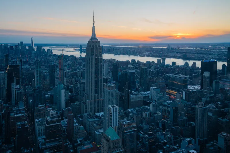 CityPASS: bundled attraction tickets for US and Canadian city breaks The Manhattan skyline at sunset seen from high above, with a tall art deco tower in the centre
