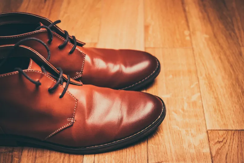 Pair of brown leather lace-up boots on a wooden floor