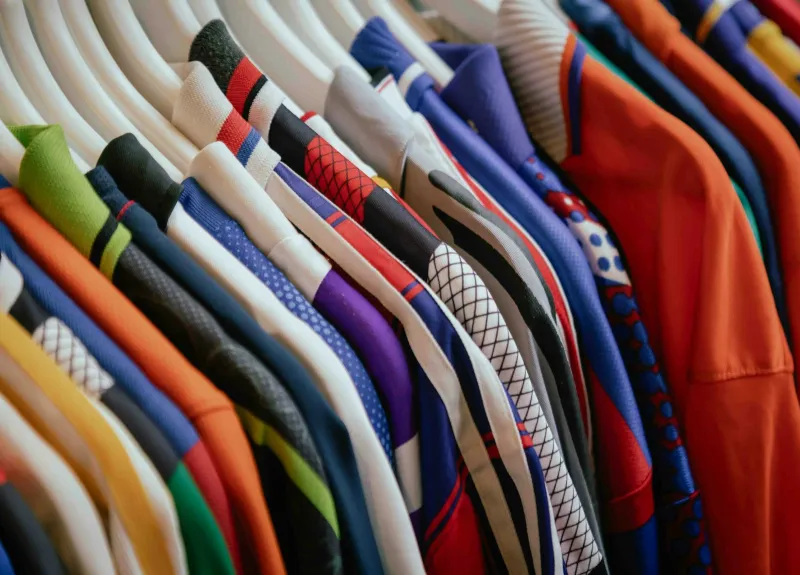 Rail of brightly coloured patterned shirts on white hangers
