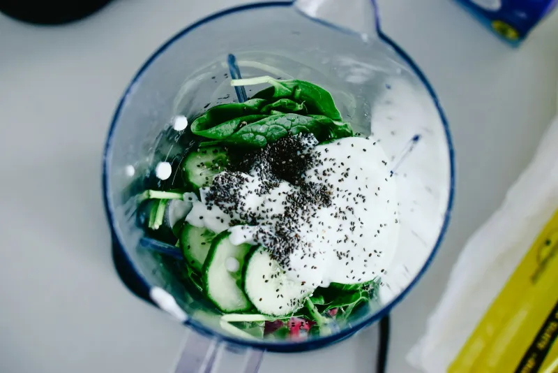 Spinach, cucumber, yoghurt and chia seeds in a blender jug, ready for a smoothie