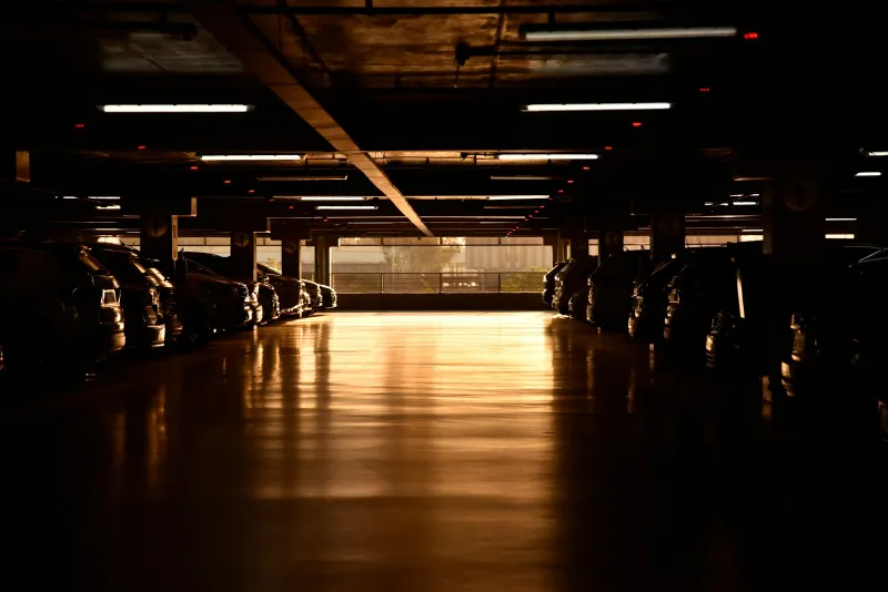 Rows of cars in a multi-storey car park lit by evening sun