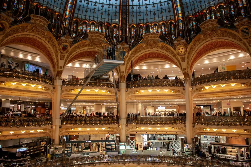 Ornate department store interior with several balconied floors under a glass dome