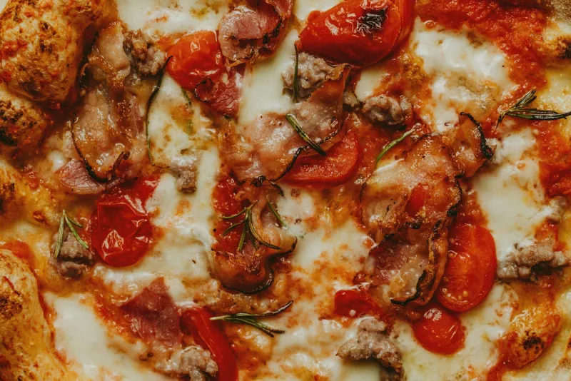 Pizza topped with tomatoes and melted cheese