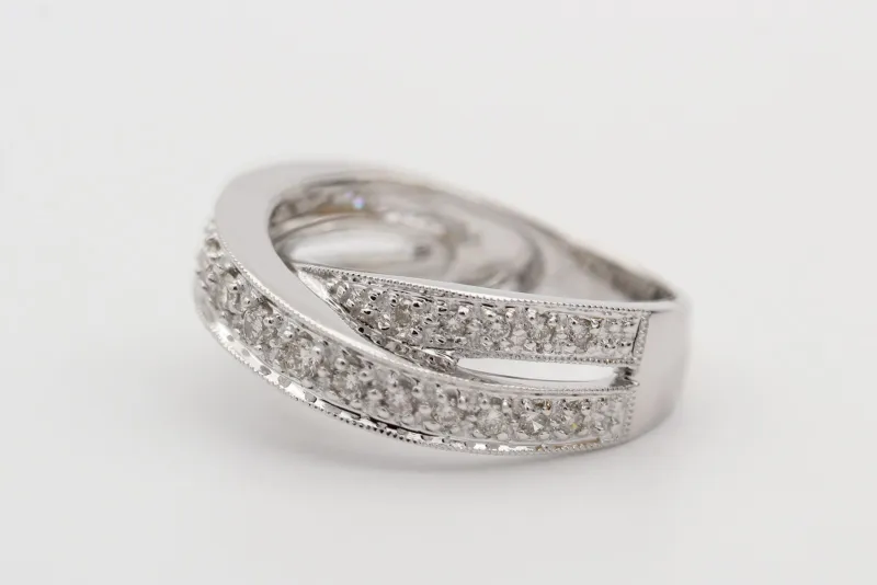 White gold ring set with rows of small diamonds on a pale background