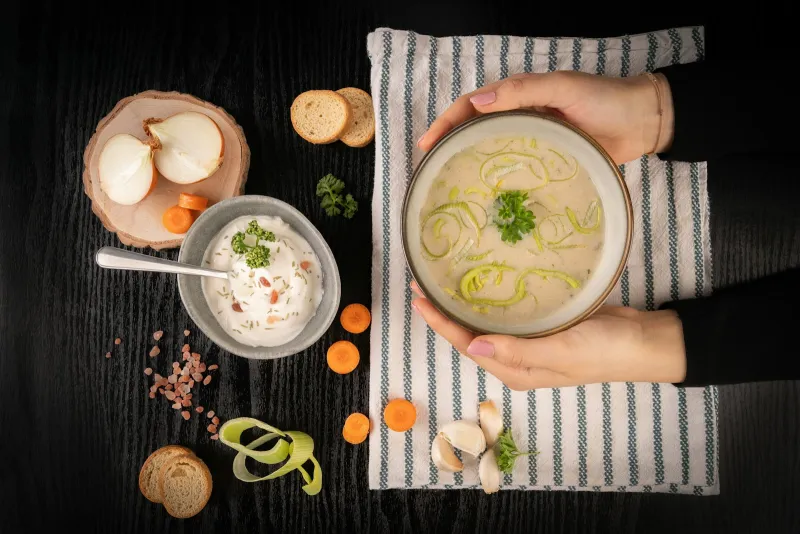 Electrolux Small Domestic Appliances: soup makers, heaters and floorcare A bowl of creamy leek soup held over a striped cloth with vegetables around it