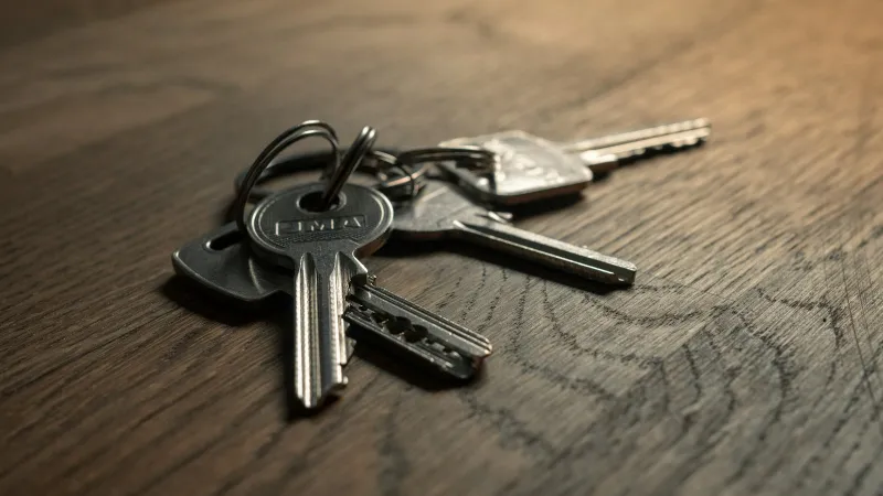 Bunch of house keys on a dark wooden table