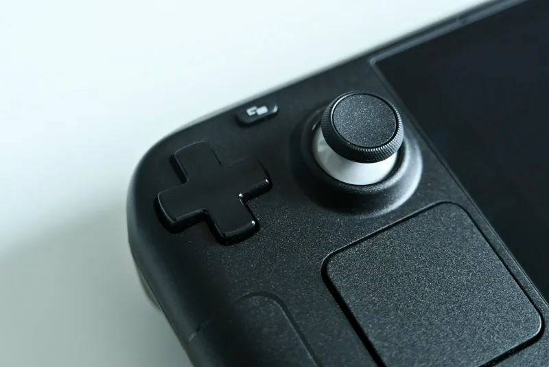 Close-up of the D-pad and thumbstick on a black handheld games console
