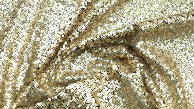Goddiva: occasion dresses from £48 and the codes that cut the price Close-up of draped gold sequin fabric