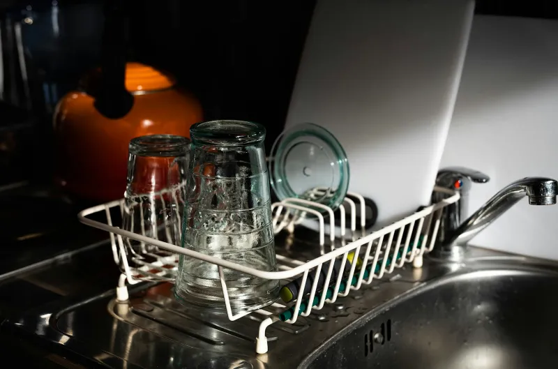 HAVA: tabletop dishwashers and a portable washer for small spaces Clean glasses drying in a wire rack beside a kitchen sink